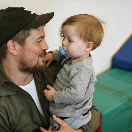 Mand holder sit barn i armene