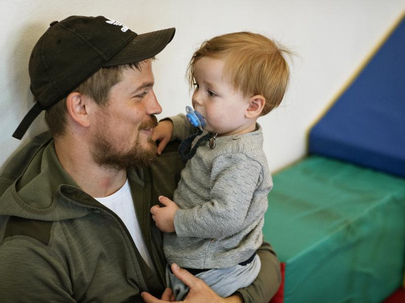 Mand holder sit barn i armene